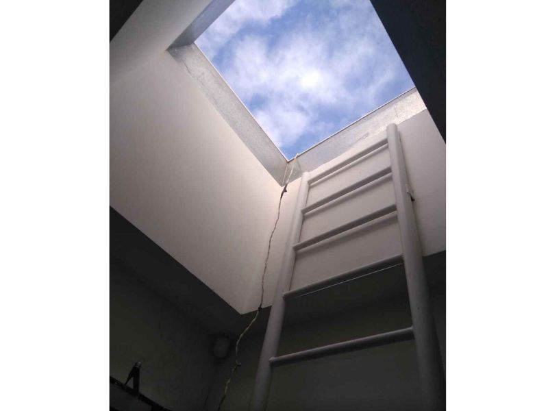 На фото видно сходи, що ведуть на дах будівлі та шматочок блакитного зимового неба.