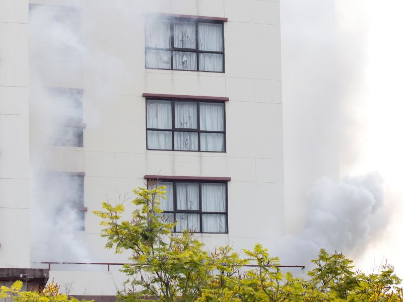 Біла будівля високоетажна находиться в диму 