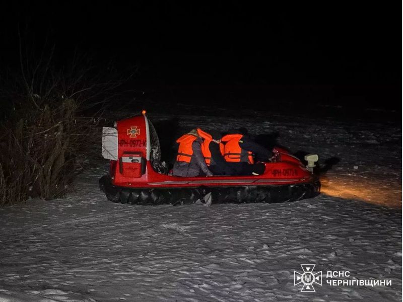 Червоне судно на повітряній подушці ДСНС Чернігівщини перевозить людей у помаранчевих рятувальних жилетах вночі по снігу під час евакуації.