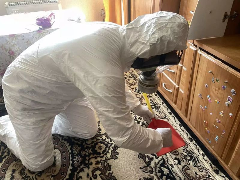 Сотрудник ДСНС в защитном снаряжении выполняет очистку помещения от разлившейся ртути.