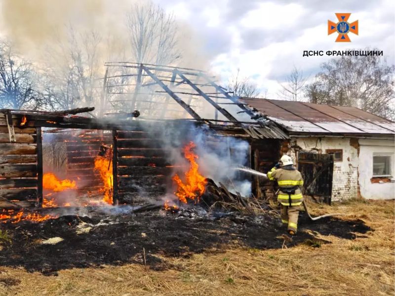 Пожарный ГСЧС тушит сильный пожар в деревянной хозяйственной постройке в Ивано-Франковской области. Огонь охватил стены и крышу здания.