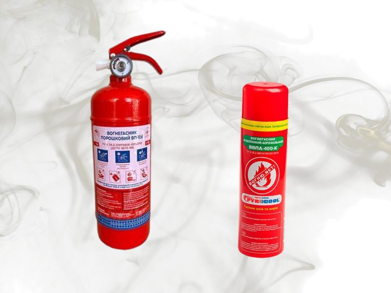 На фоні задимлення два вогнегасники, один порошковий, а інший аерозольний маленький.