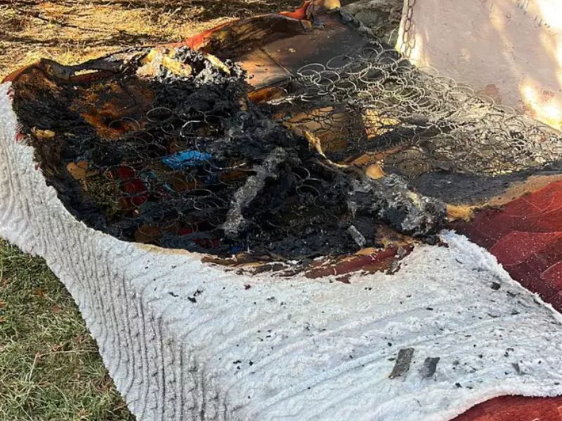 Сгоревший матрас с торчащими металлическими пружинами лежит на траве после пожара в частном доме на Закарпатье.