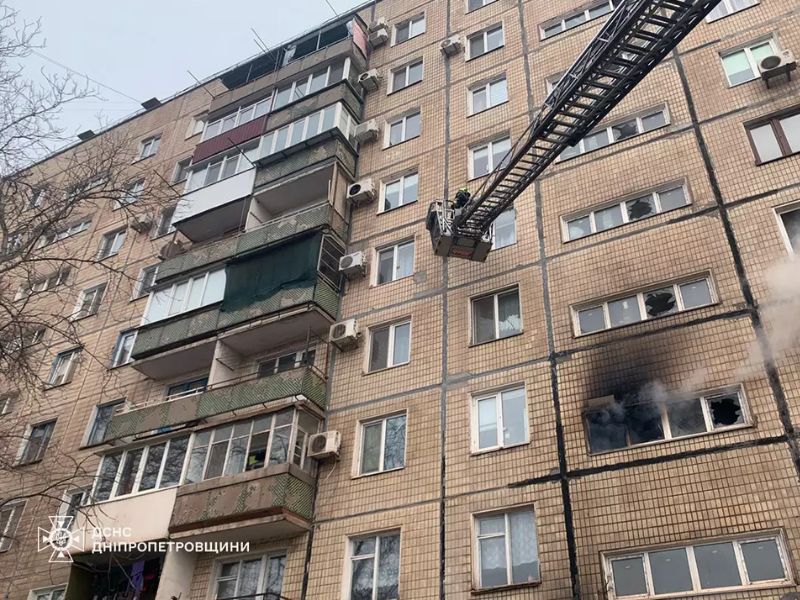 Пожарная автолестница ГСЧС поднята к верхним этажам многоэтажки во время пожара в Днепропетровской области, черный дым из окна квартиры, спасательные работы на высоте.