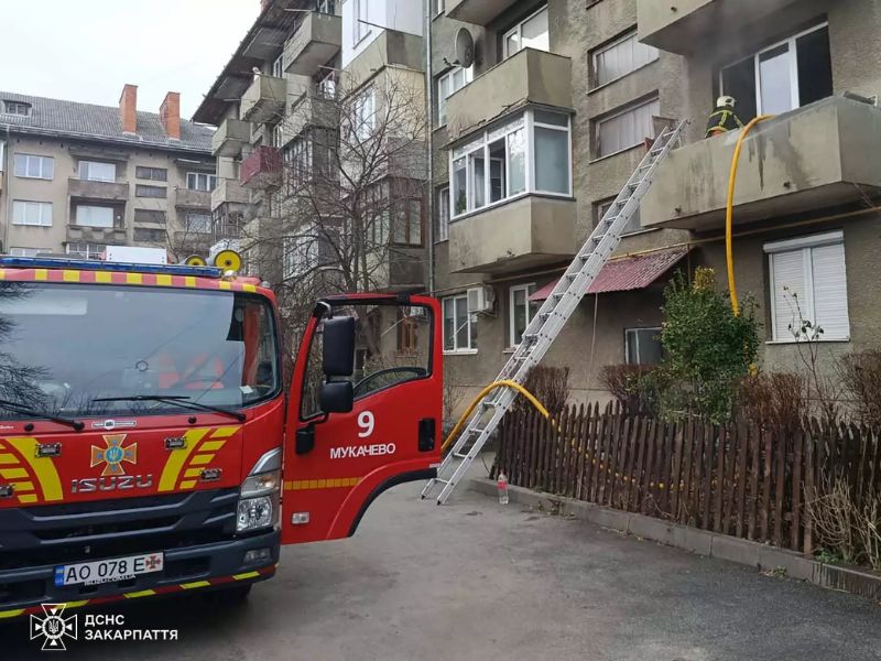 Рятувальники ДСНС Мукачева ліквідовують пожежу у квартирі багатоповерхівки. Пожежне авто Isuzu розгорнуто у дворі, вогнеборець за допомогою висувної драбини дістався балкона другого поверху для гасіння осередку займання.