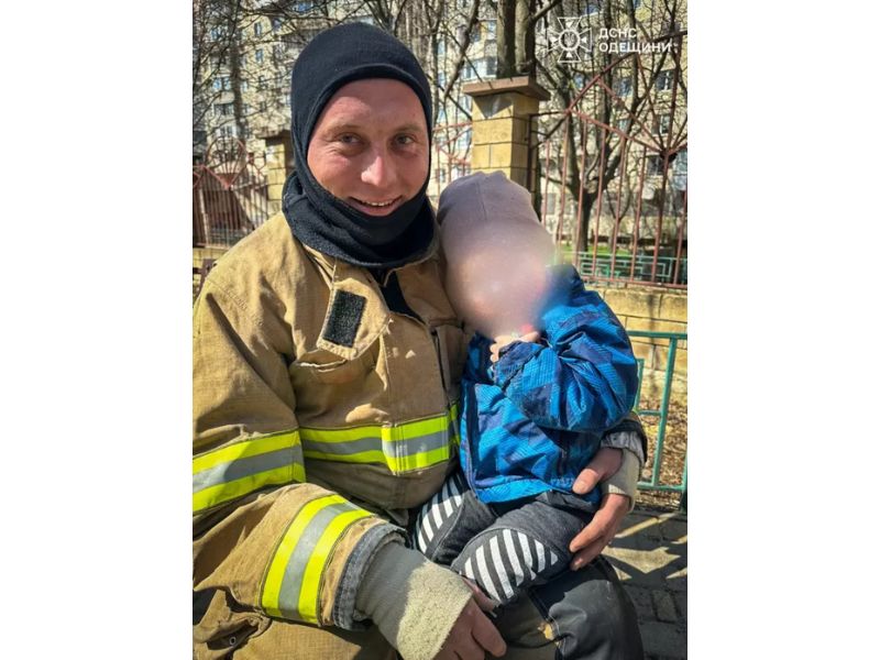 Пожежник ДСНС Одещини з дитиною на руках після проведення успішної рятувальної операції.
