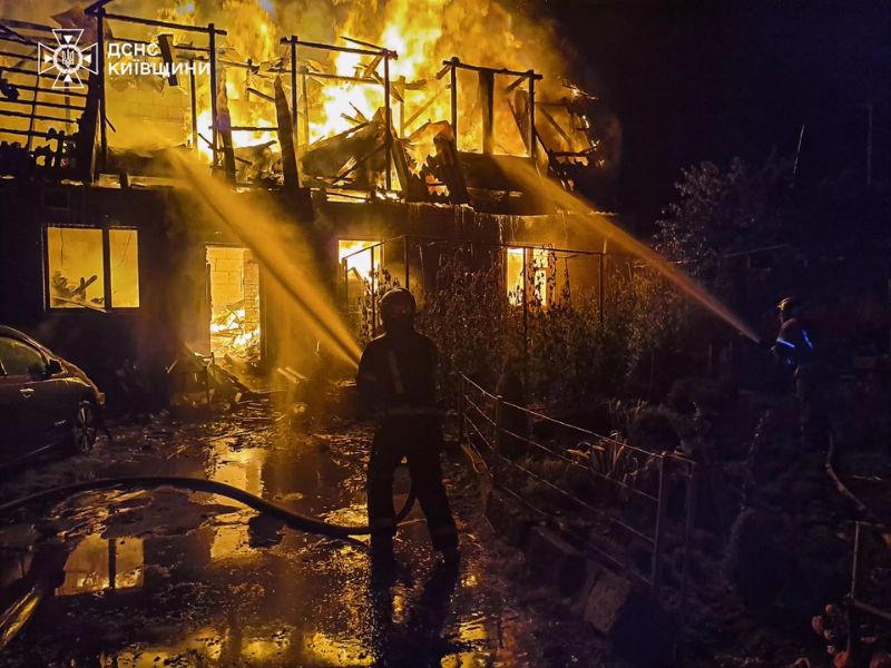 Рятувальники ДСНС ліквідовують масштабну пожежу в житловому будинку в Боярці, подаючи воду на палаючий дах та другий поверх будівлі.