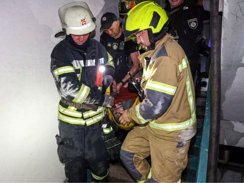 Вогнеборці ДСНС евакуюють постраждалу жінку сходовою кліткою дев'ятиповерхового житлового будинку.