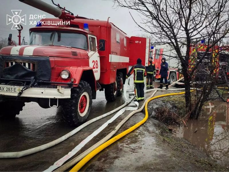 Пожарные машины ГСЧС в Изюме Харьковской области, спасатели разворачивают пожарные рукава для тушения, красная спецтехника 28-й части на месте происшествия.