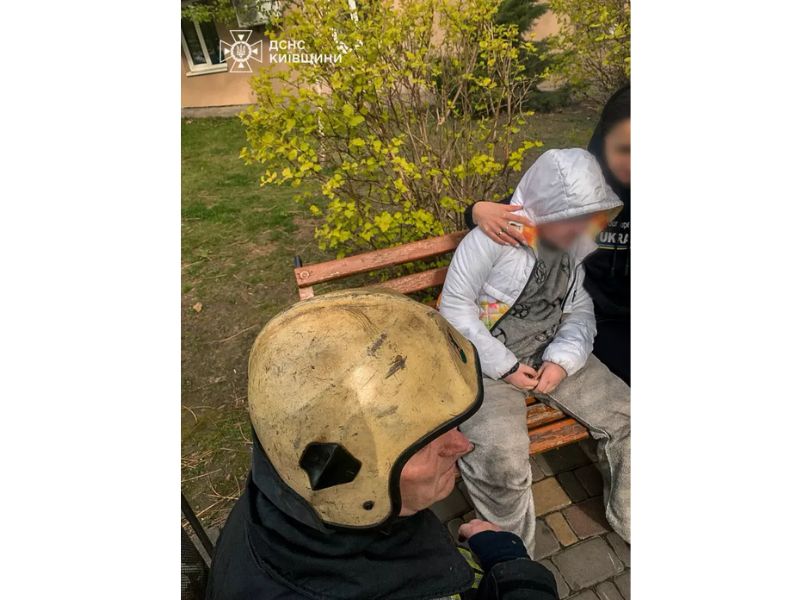 Співробітник ДСНС надає психологічну допомогу дитині на місці події у Київській області.