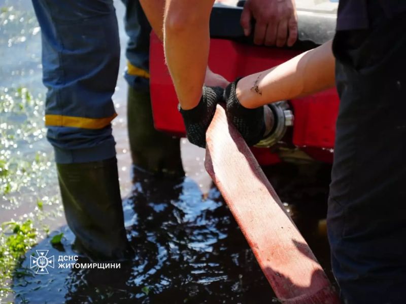 Крупний план: рятувальники ДСНС працюють з пожежним рукавом прямо у воді на підтопленій ділянці.