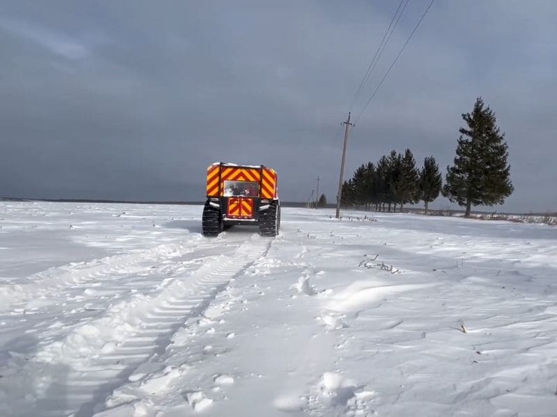 Снегоболотоход «Богун» ГСЧС Украины едет по глубокому снегу через поле, доставляя ремонтную бригаду энергетиков для восстановления света в Ивано-Франковской области