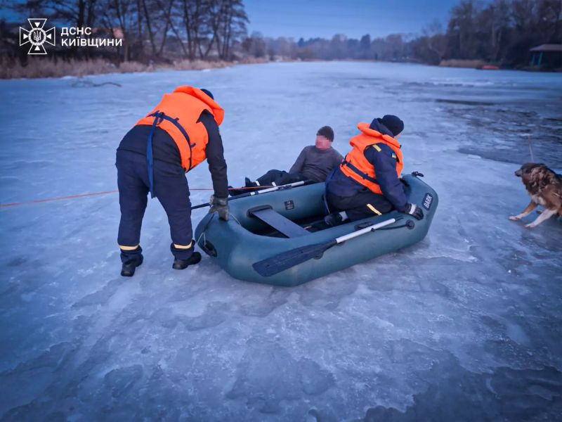 Рятувальники ДСНС Київщини рятують чоловіка, який опинився на тонкій кризі, використовуючи надувний човен та спеціальне спорядження.