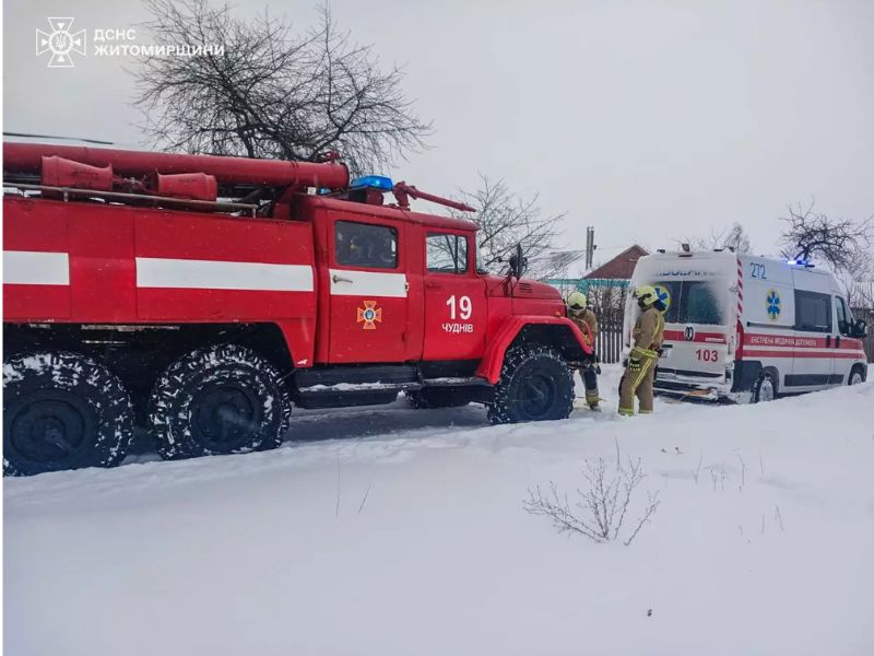Пожарный автомобиль ДСНС 19 части города Чуднов буксирует застрявшую в снегу машину скорой помощи. Спасатели помогают медикам выбраться из сугроба на заснеженной дороге в Житомирской области.