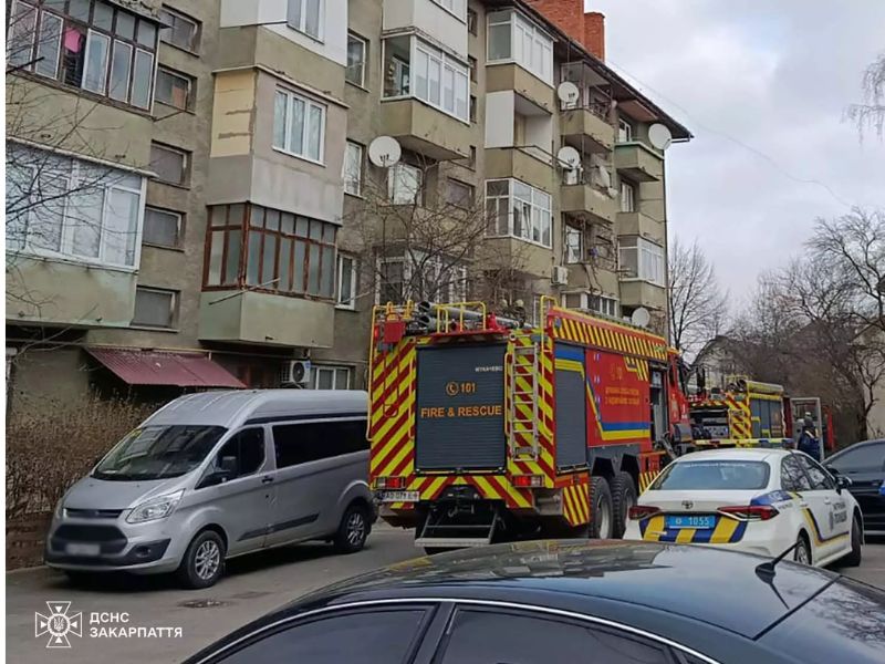 Пожежний автомобіль ДСНС та машина патрульної поліції у дворі багатоповерхівки в Мукачеві. Спільна робота рятувальників та правоохоронців на місці ліквідації пожежі в житловому секторі Закарпаття.