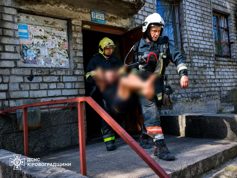 Співробітники ДСНС виносять постраждалого чоловіка із задимленої будівлі під час пожежі в гуртожитку міста Світловодськ.