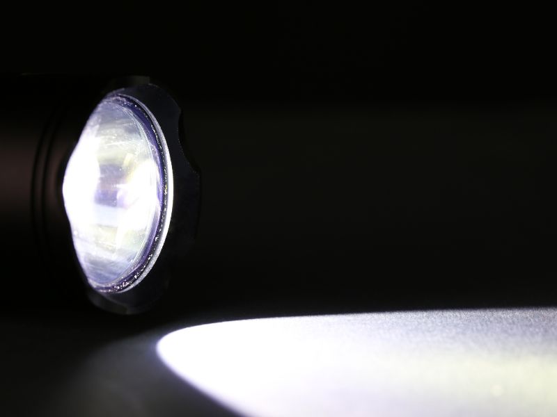 На чорному фоні знаходиться в темряві включений фонарик, що є включений